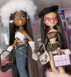 two dolls are posed next to each other