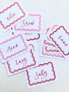 four red and pink scalloped name tags on a white surface with the word sale written in cursive writing