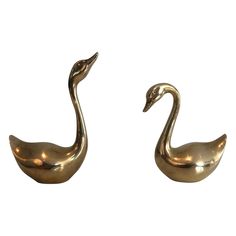 pair of brass swan sculptures on white background