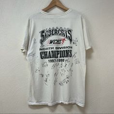 Vintage ‘97-‘98 Tacoma Supercats Wchl Champions Autographed Tee Sz Large Super Cool Tee! Looks Like It Was Signed By 21 Players, This Has No Coa Sadly This Is Stained, Can’t Be Washed Due To Signatures. White Throwback Graphic Print Tops, White Throwback Top With Dtg Printing, 90s Style White T-shirt, Sporty 90s White Tops, 90s Graphic Print Tops For Fan Gear, Shirts Vintage, Cool Tees, Super Cool, Autograph