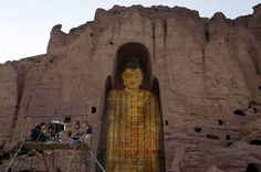 a giant buddha statue sitting in front of a mountain