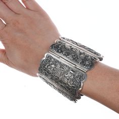 Large Antique Chinese Repousse silver bracelet.  A few small pinholes in the design, amazing wearable work of art, all hand chased.   Measurements and weight shown, no significant issues.   And yes I do realize my wife is wearing this upside down, I guess if it's your you wear it how you like.  To her it made sense to flare out for your hand and for you to see the design right side up while wearing it.   But I believe it was intended to be worn by someone with arms that perhaps got really plump Carved Sterling Silver Bracelet, Carved Sterling Silver Bracelets, Elegant Carved Silver Cuff Bracelet, Elegant Silver Carved Bracelets, Elegant Silver Bracelets With Carved Details, Unique Engraved Bracelets For Formal Occasions, Unique Engraved Sterling Silver Bracelet For Formal Occasions, Silver Carved Bracelet For Ceremonial, Silver Carved Bracelet