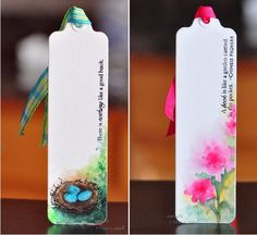 two tags with bird's nest and pink flowers on them, one has a blue egg in it