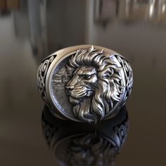 Showcase your inner strength with our Lion Head Ring, meticulously handcrafted from 925 Sterling Silver. This impressive piece features the majestic lion, known as the king of the jungle, making it an ideal accessory for wildlife enthusiasts, fans of bold jewelry, and those drawn to the symbolism of strength and courage. Our Lion Head Ring exhibits a strikingly sculpted lion's head, a symbol of bravery and power. The design is beautifully rendered in high-quality sterling silver, highlighting ea Adjustable Carved Sterling Silver Jewelry, Symbolic Carved White Gold Jewelry, Custom Engraved Silver Jewelry, Custom Silver Handmade Engraved Ring, Custom Handmade Silver Engraved Ring, Custom Handmade Silver Jewelry, Handmade Custom Sterling Silver Signet Ring, Carved White Gold Sterling Silver Jewelry, Custom Sterling Silver Jewelry With Polished Finish