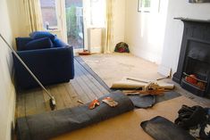 a living room filled with lots of clutter and items on the floor next to a fire place