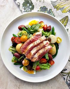 a white plate topped with meat and veggies