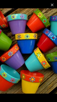 colorful plastic cups with flower designs on them sitting on top of a wooden table next to each other