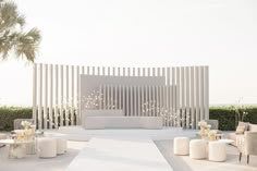 an outdoor seating area with white furniture and palm trees in the background, on instagram