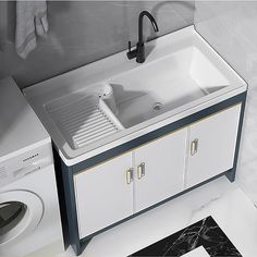 a white kitchen sink sitting next to a washer and dryer in a bathroom