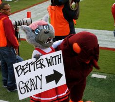 the mascot is holding a sign that says better with gravy in front of him