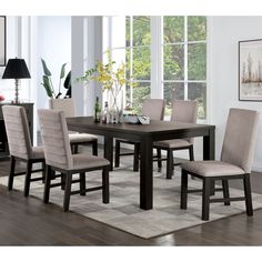 a dining room table with chairs and a rug