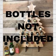 a wooden christmas tree made out of bottles with the words bottles not included on it