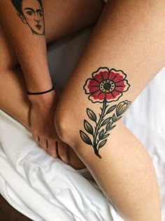 two women with tattoos on their legs and one has a flower tattoo on her leg