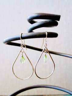 beautiful Gold filled 14k teardrop hoop earrings with chain dangle. The peridot gemstone brings the character to this design with a pop of color and still discrete .  Peridot is known as the stone of compassion. Its earthy color allows it to be worn with almost everything.  Its luminous energy is perfect for Summer, it will brighten your autumn and winter wardrobe. Comes with rubber earring backs. Matching necklace available. Please message me if you have any questions. Thank you for your suppor Silver Teardrop Hoop Earrings In 14k Gold, Modern Teardrop Pendant Jewelry With Ear Wire, Silver 14k Gold Teardrop Hoop Earrings, Modern Teardrop 14k Gold Filled Jewelry, Modern 14k Gold Filled Teardrop Jewelry, Handmade Teardrop 14k Gold Hoop Earrings, Everyday Green Teardrop Pendant Jewelry, Modern Gold Jewelry With Peridot, Minimalist Green Teardrop Pendant Jewelry