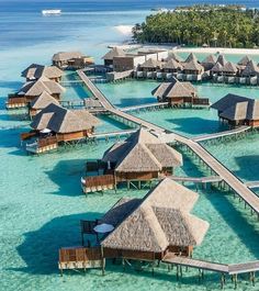 an aerial view of over water huts and walkways in the middle of the ocean