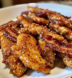 chicken wings covered in bbq sauce on a white plate with sesame seed sprinkles