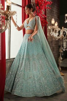 Icy mint blue lehenga with attached can-can, all over floral vintage pattern, tonal cut dana, sequin and pearl embroidery. Paired with plunged V neck padded blouse with cut work waist, bead tasselled hem and embroidered dupatta.
Components: 3
Pattern: Hand Embroidered
Type Of Work: Cut Dana, Sequin and Pearl Work
Neckline: Plunged V Neck
Sleeve Type: Sleeveless
Fabric: Net
Color: Blue
Other Details: 
Cut work back
Weight approx (in kgs): 5
Blouse Closure: Back tie-up, hook and eye
Note: All the Teal Lengha Bridal Lehenga, Sea Blue Lehenga, Turquoise Lengha, Annus Creation, Ice Blue Lehenga, Sangeet Outfit Bridal, Pearl Lehenga, Light Blue Lehenga, Sky Blue Lehenga