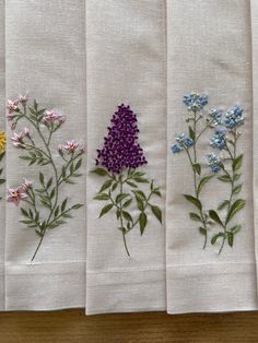 four embroidered napkins with flowers on them