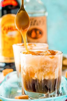 a spoon is pouring caramel syrup into an ice cream sundae on a blue plate