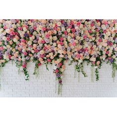 an arrangement of flowers on a brick wall