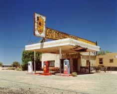 an old gas station in the middle of nowhere, with no cars parked outside it