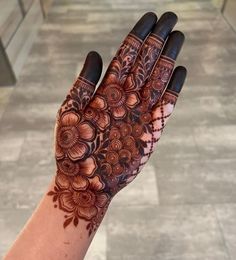 a woman's hand with henna tattoos on it