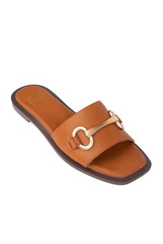 Women's Tan Wide Mule Memory Foam Square Toe Flat Slip-On Sandals Ava Flats These flat sandals feature a wide mule design and gold brake hardware detail, along with a memory foam insole for added comfort. Complete your wardrobe with the perfect sandals - they're right here! Don't pass up on our newest collection of stylish and comfortable sandals. They slip on easily and have a square toe for extra flair. Shop the rest of our shoe collection HERE. Details Available in sizes: 5-10 Available in co Beach Open Toe Sandals With Gold Buckle, Summer Open Toe Sandals With Gold Buckle, Open Toe Sandals With Gold Buckle For Summer, Spring Beach Sandals With Gold Buckle, Beach Sandals With Gold Buckle For Spring, Summer Open Toe Footbed Sandals With Gold Buckle, Spring Open Toe Slides With Gold Buckle, Open Toe Footbed Sandals With Gold Buckle For Summer, Open Toe Slides With Gold Buckle For Spring