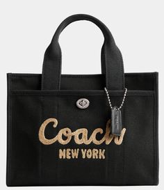 From COACH&#x2C; the Small Cargo Tote 26 Bag features:Canvas&#x2C; grosgrain&#x2C; and recycled leatherZip-top closureFabric liningHandles with 4" dropOutside turn-lock and snap pocketsDetachable strap with 24" drop for shoulder or crossbody wearFits an iPadApprox.: 10.25" L x 7.75" H x 5" WImported. Coach Tote Bags, Casual Chique, Coach Logo, Coach New York, Coach Tote, Recycled Leather, Women Cargos, Mini Tote, Black Tote Bag