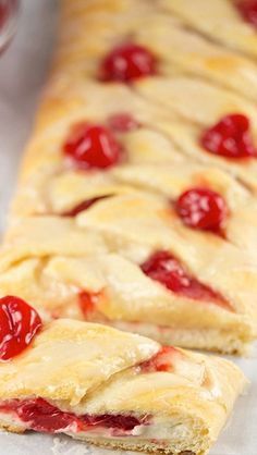 two pieces of pastry with cherries on them