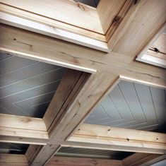 the ceiling is made out of wood and has three beams on each side with one beam missing