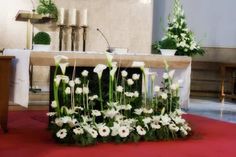 the altar is decorated with white flowers and greenery