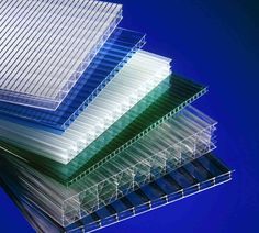 three stacks of clear plastic sheets stacked on top of each other in front of a blue background