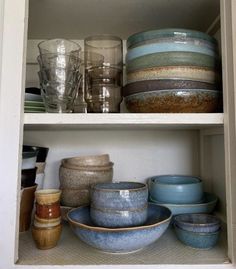 dishes and cups are sitting on the shelves