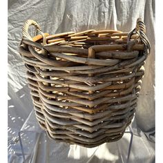 a woven basket hanging on a white sheet