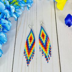 These colorful beaded earrings are sure to add a cute pop of color to any boho chic look or summer outfit. Part of our Desert Sunset Collection, these bohemian fringe earrings feature beautiful colors to wear all year long (navy blue, yellow, orange and turquoise). With an Exclusive Colorful 4U design, these seed bead earrings in boho chic style are part of the traditional Emberra art and culture, combining stylish designs with ancient tribal patterns and craftsmanship.  Details: Lightweight lon Colorful Beaded Teardrop Earrings For Beach, Bohemian Teardrop Beaded Earrings With Colorful Beads, Teardrop Earrings With Colorful Beads For Beach, Teardrop Beach Earrings With Colorful Beads, Summer Orange Earrings With Tiny Beads, Bohemian Rainbow Beaded Earrings For Summer, Rainbow Beaded Dangle Earrings For Summer, Rainbow Bohemian Beaded Drop Earrings, Summer Rainbow Beaded Earrings With Dangling Beads