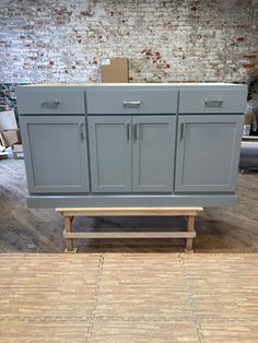 a gray cabinet with two drawers and a bench