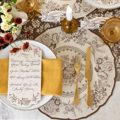 a table setting with place settings and flowers