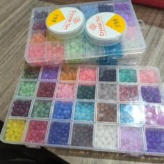 two plastic containers filled with different colored beads