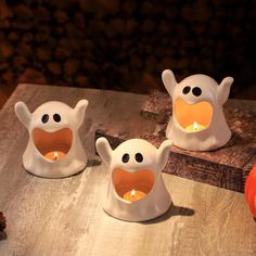 three halloween candles are sitting on a table