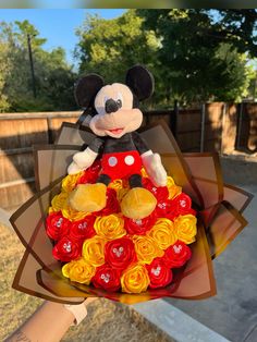 a hand holding a mickey mouse bouquet