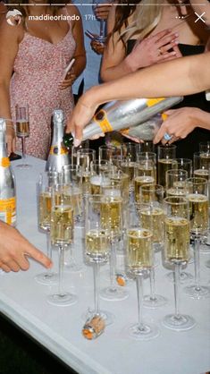 several people standing around a table filled with champagne