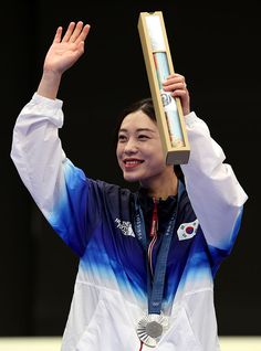 the woman is holding up her gold medal