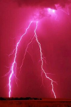 two lightning strikes in the sky over a field