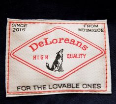 the label for deloreans high quality clothing on a black jacket with red and white trim