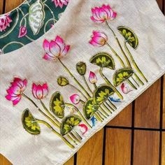 the table cloth is decorated with pink flowers and green leaves, on top of a wood floor