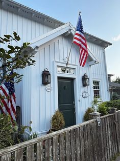 an american flag is hanging on the side of a white building