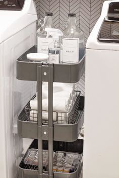 a white washer and dryer sitting next to each other in a room with tile walls