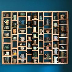 a wooden shelf filled with lots of cups