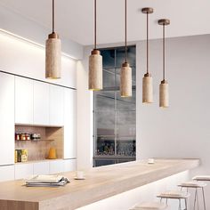 a long counter with four stools in front of it and several lights hanging from the ceiling