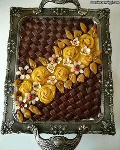 there is a decorative tray with yellow flowers on the side and chocolate in the middle